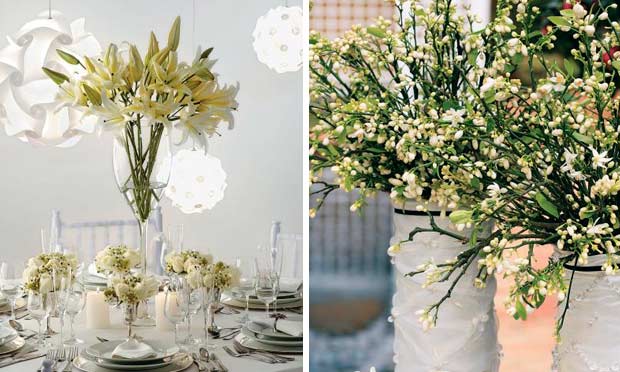 Mesa decorada em tons de branco com lustres redondos e flor de laranjeira