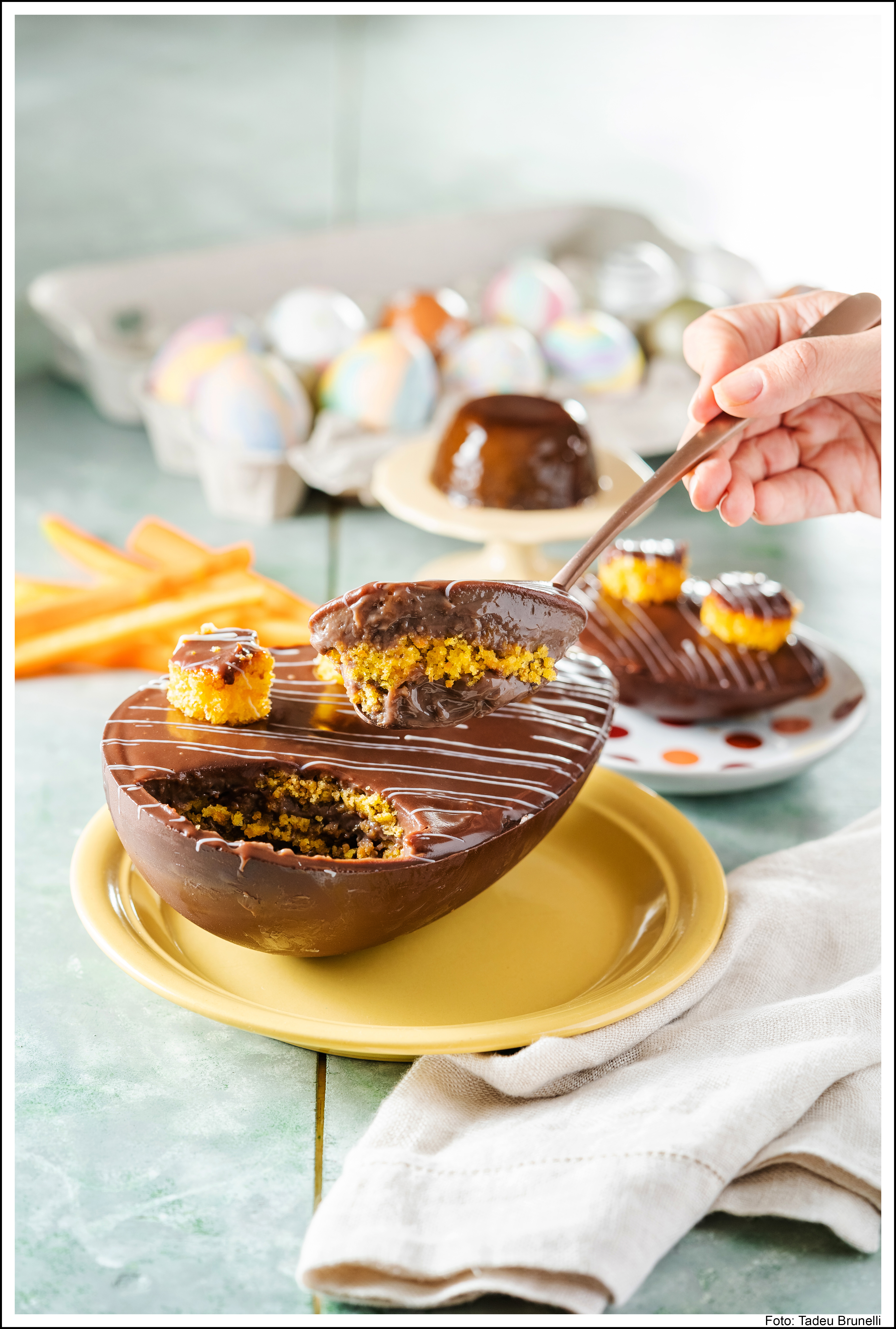 Dona De&ocirc;la - Ovo Bolo de Cenoura com Pudim de Chocolate. Casca de chocolate recheada de bolo de cenoura e pudim de chocolate cremoso, coberto com ganache de chocolate e mini bolos de cenouras. Pre&ccedil;o: R$ 69,90.