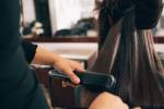 Cabeleireira fazendo chapinha em cabelo de cliente
