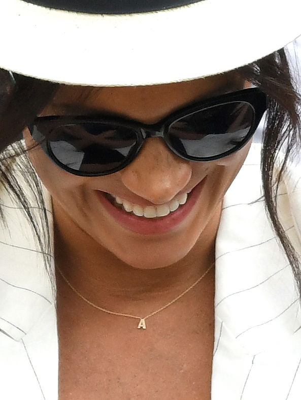 Meghan Markle usando colar com a inicial 
