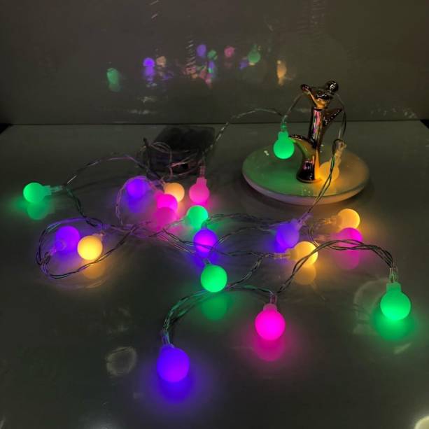 Cord&atilde;o de luzes coloridas, com 2 m, 20 l&acirc;mpadas bolinhas de LED, funciona com 3 pilhas AAA.<a href="https://www.elo7.com.br/2-luminaria-cordao-luz-led-20-bolinhas-1-5cm-varal-2m-color/dp/F5976E?pp=11&pn=1&nav=sts_ps_sr_1_11&qrid=NZqQJWSPOiEf#dmcl=1&rcp=1&hpa=0&ps2=1&sdps=0&rch=1&hsv=1&pcpe=1&ucrq=1&npc=1&supc=1&carf=0&droam=0&df=d&rps=0&srm=1&vpl=1&fsfv=0&sew=0&sami=1&sms=0&spc=1&staa=0&smsm=0&usb=0&ses=0&rcpd=1&sei=0&disc=0&suf=0&sura=0&smps=0&rfn=0&sedk=1&scsa=1&sewb=1&uso=m&smc=1&idfs=1&sum=0&sep=0&cpr=0&fnc=0&secpl=1&doar=0&inp=0&sed=1" target="_blank" rel="noopener"> Elo 7 (Loja do Guru_Rio)</a>, R$ 59,98