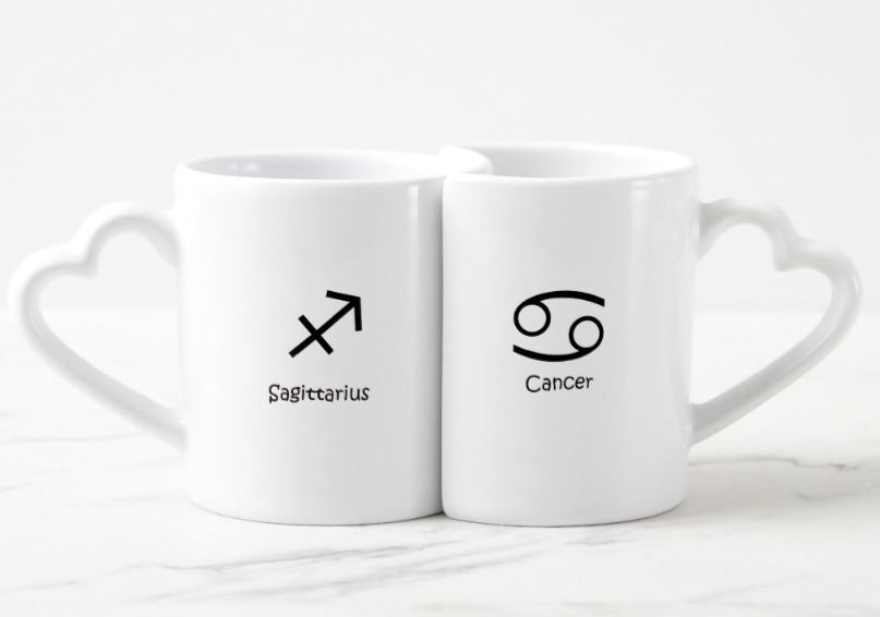 Conjunto de canecas Lovers Astrologia do Zodíaco, de cerâmica com alças de coração. <a href="https://www.zazzle.com.br/conjunto_de_caneca_de_cafe_astrologia_dos_zodiacos_do_caranguejo_do_cancer_do-256654322775101845" target="_blank" rel="noopener">Zazzle</a>, R$ 90,65