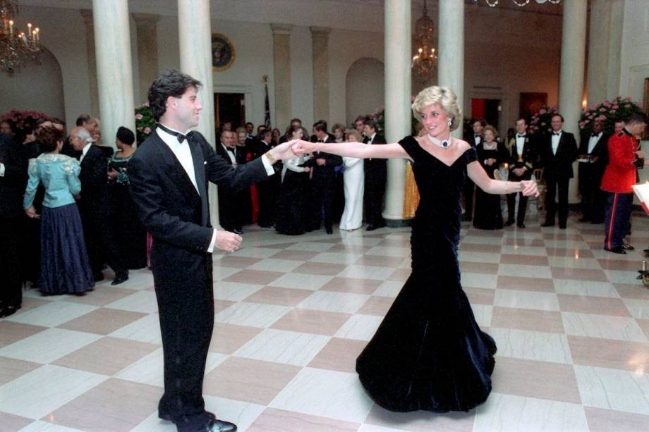 <span>A princesa Diana dan&ccedil;ou com o ator John Travolta em um jantar do presidente Raegan na Casa Branca, em 1985, usando este vestido de veludo feito sob medida por Victor Edelstein. Leiloado pela primeira vez em 1997 por &pound;100,000, o vestido ic&ocirc;nico foi vendido de novo em 2013 por &pound;240,000.</span>