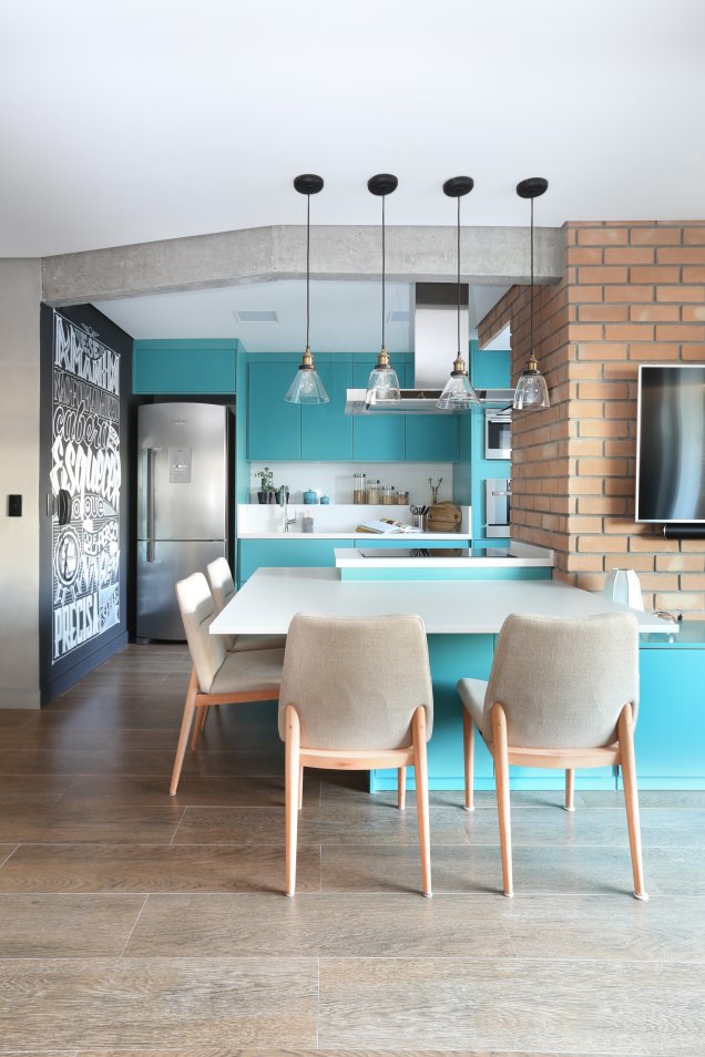 O canto de jantar deste apartamento idealizado pelo escritório <a href="https://www.quattrinoarquitetura.com.br" target="_blank" rel="noopener">Quattrino Arquitetura</a> foi projetado em L, na divisão entre a sala e a cozinha. A marcenaria laqueada de azul unifica as áreas integradas.