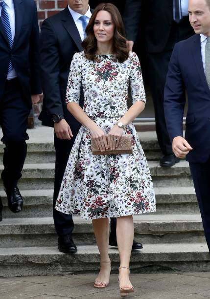 <strong>16 de julho de 2017</strong> - Em sua segunda aparição no torneio de Wimbledon de 2017, Kate foi fotografada usando um vestido branco estampado com flores delicadas e coloridas. Para arrematar, bolsa tote, também branca, assinada por Victoria Beckham.