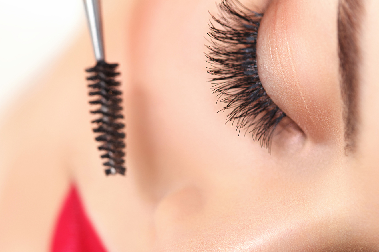 Olho feminino e aplicador de m&aacute;scara para c&iacute;lios