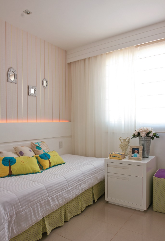 <span>As listras verticais do delicado papel de parede contrastam com as faixas horizontais do painel e do cortineiro. Sobre a cama, almofadas com estampas fofas acompanham as cores da decora&ccedil;&atilde;o.</span>