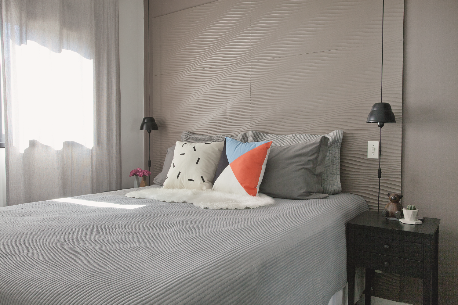 <span>No quarto, tudo gira em torno da cabeceira: &ldquo;S&atilde;o placas de pl&aacute;stico que tamb&eacute;m foram decora&ccedil;&atilde;o de uma vitrine que montei&rdquo;, conta a designer de interiores Priscila Kolberg.&nbsp;</span><span>As almofadas divertidas apimentam a cena (modelos Risco, preto e branco, e Sally, colorido, de 45 x 45 cm. Astor)</span>