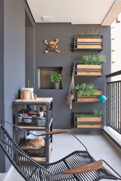 <span>Na varanda – cinza por sorte, já que essa é a cor da fachada do prédio -, ervas frescas brotam de jardineiras: são caixotes de madeira apoiados em suportes de ferro trazidos do endereço anterior.</span> <span>Na varanda – cinza por sorte, já que essa é a cor da fachada do prédio -, ervas frescas brotam de jardineiras: são caixotes de madeira apoiados em suportes de ferro trazidos do endereço anterior.</span>