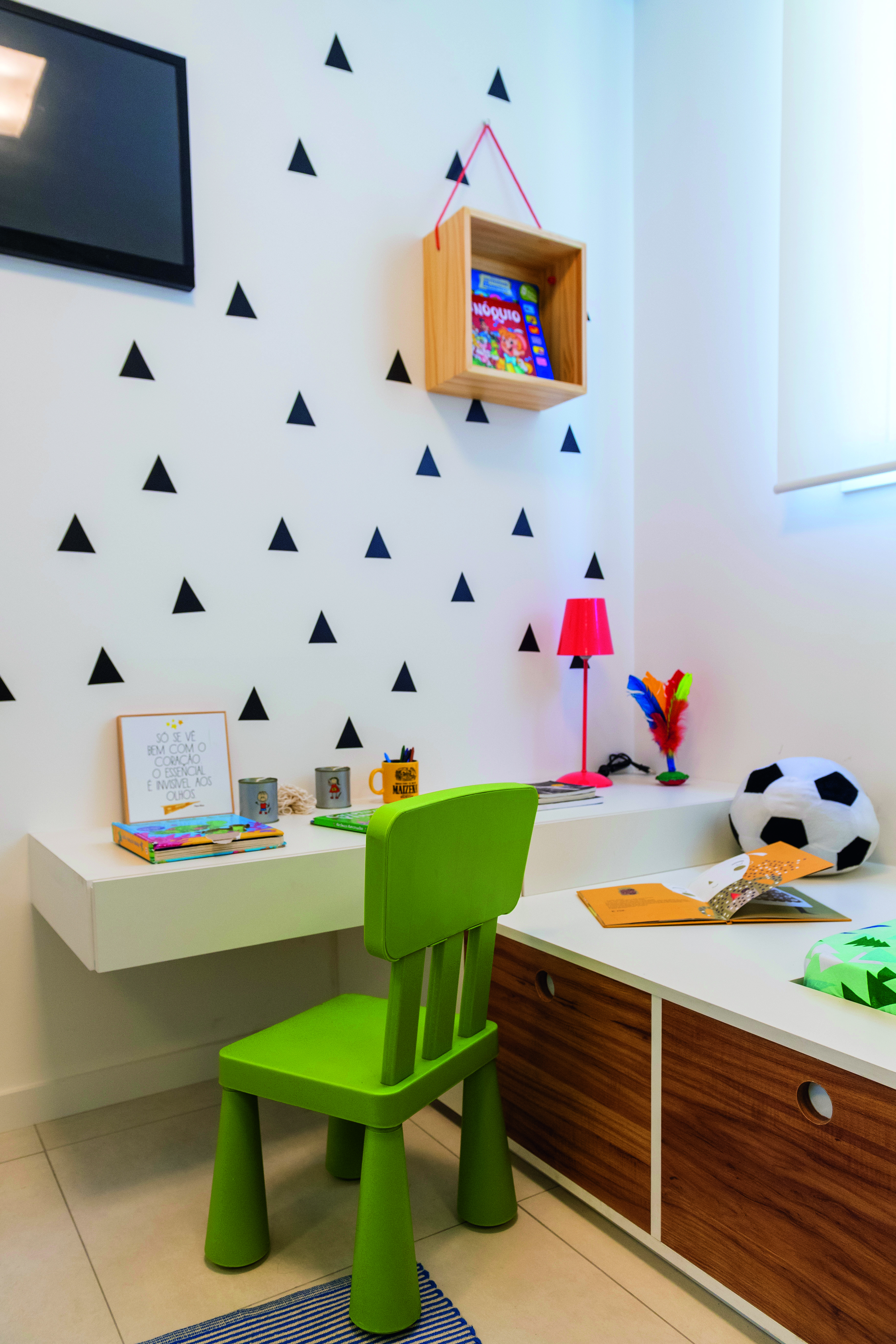 &ldquo;Quer&iacute;amos uma atmosfera l&uacute;dica para o dormit&oacute;rio infantil&rdquo;, diz Fabiana. Assim, o conjunto de escrivaninha e cama com gavet&otilde;es ganha ainda mais gra&ccedil;a combinado com o adesivo de parede (Kit Tri&acirc;ngulo Preto, com 36 pe&ccedil;as de 7 x 7 cm. Kola. Projeto das arquitetas Fabiana Silveira e Patr&iacute;cia de Palma, do escrit&oacute;rio SP Estudio.