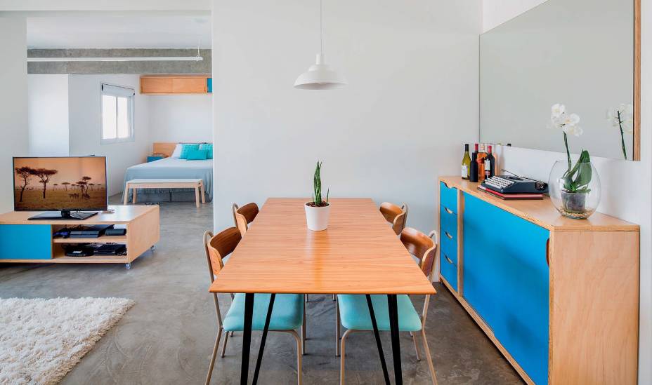 &Agrave;s refer&ecirc;ncias monocrom&aacute;ticas trazidas pelo morador, os arquitetos acrescentaram um toque brasileiro de cor: o mobili&aacute;rio de compensado, desenhado por eles e executado pela Maria Joaquina Marcenaria, tem trechos de laminado Azul Mediterr&acirc;neo (Formica) &ndash; caso do buf&ecirc;. Projeto MarcoZero Estudio.