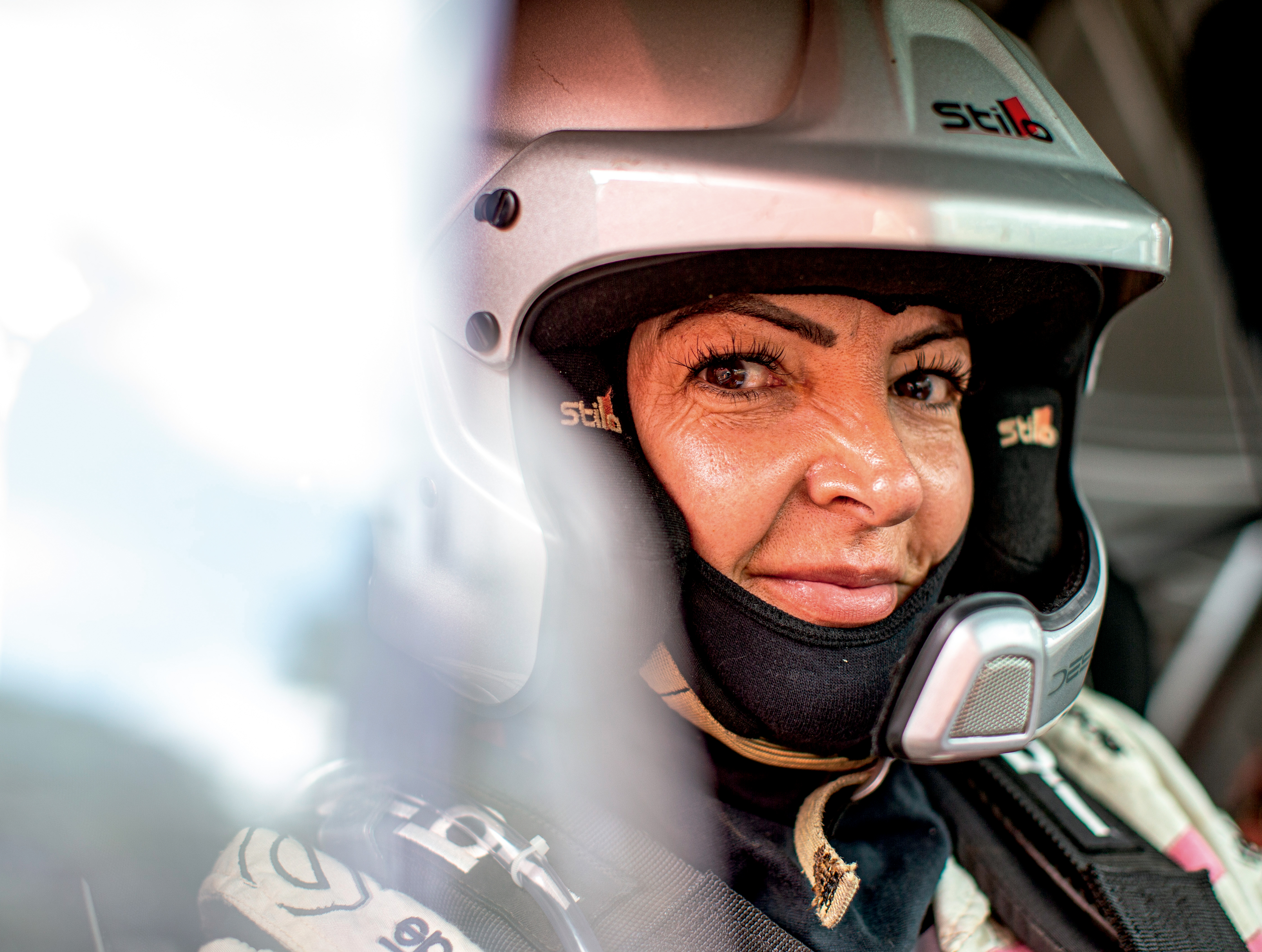Mulher branca olha para a foto. Ela est&aacute; usando um capacete