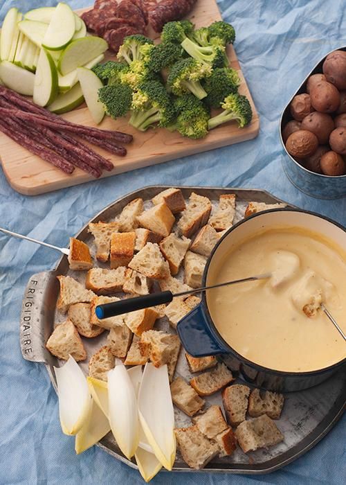 fondue de queijo servido em t&aacute;buas de metal e f&ocirc;rmas