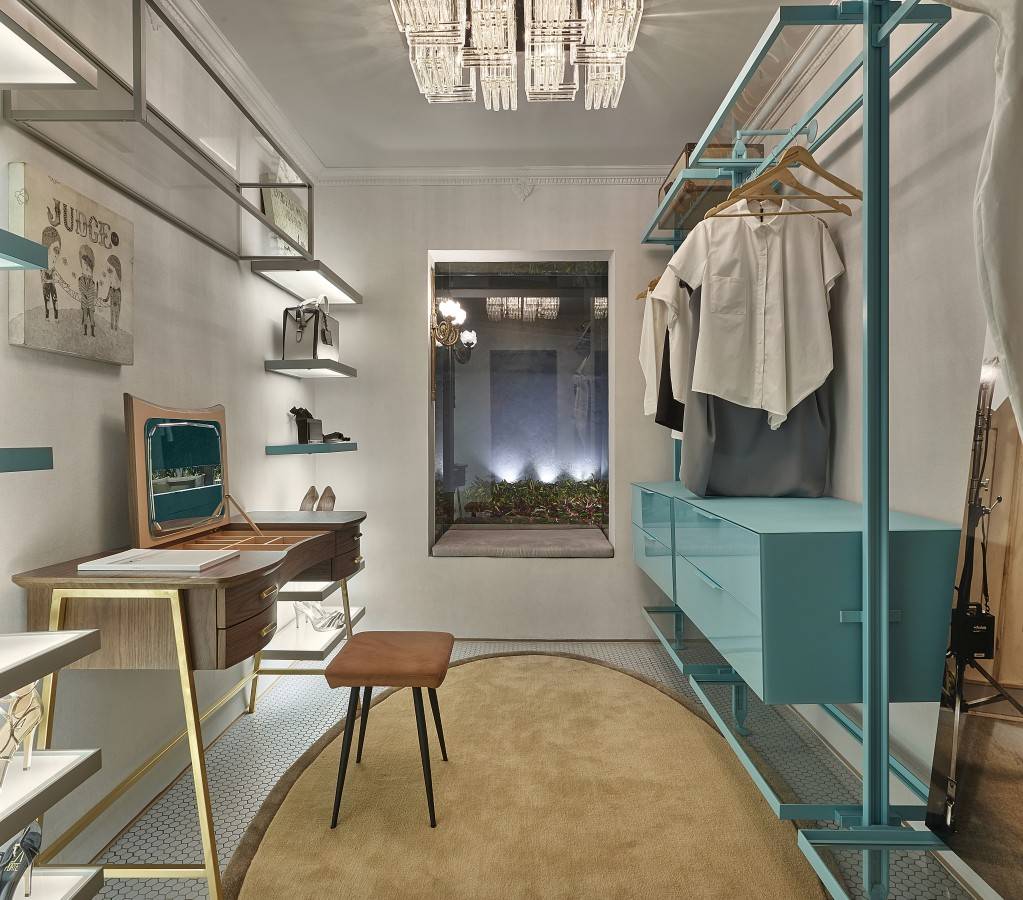 Exposto na Casa Cor MG 2015, o closet por Sarah James ganhou m&oacute;veis de design vintage e estante azul.