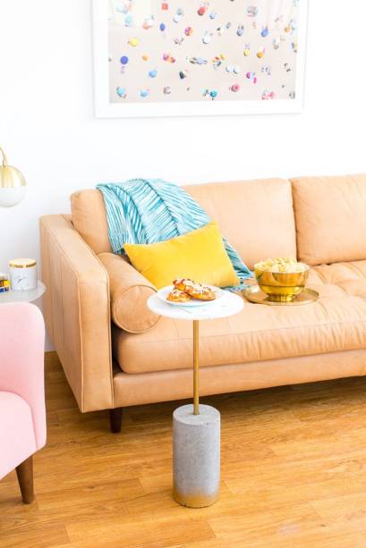 Com cimento, metal e uma pedra do seu gosto, voc&ecirc; mesmo pode fazer uma mesinha como esta para a sua sala. O tutorial, em ingl&ecirc;s, est&aacute; dispon&iacute;vel <a href="https://sugarandcloth.com/diy-marble-gold-c-table/?pp=0">aqui</a>.