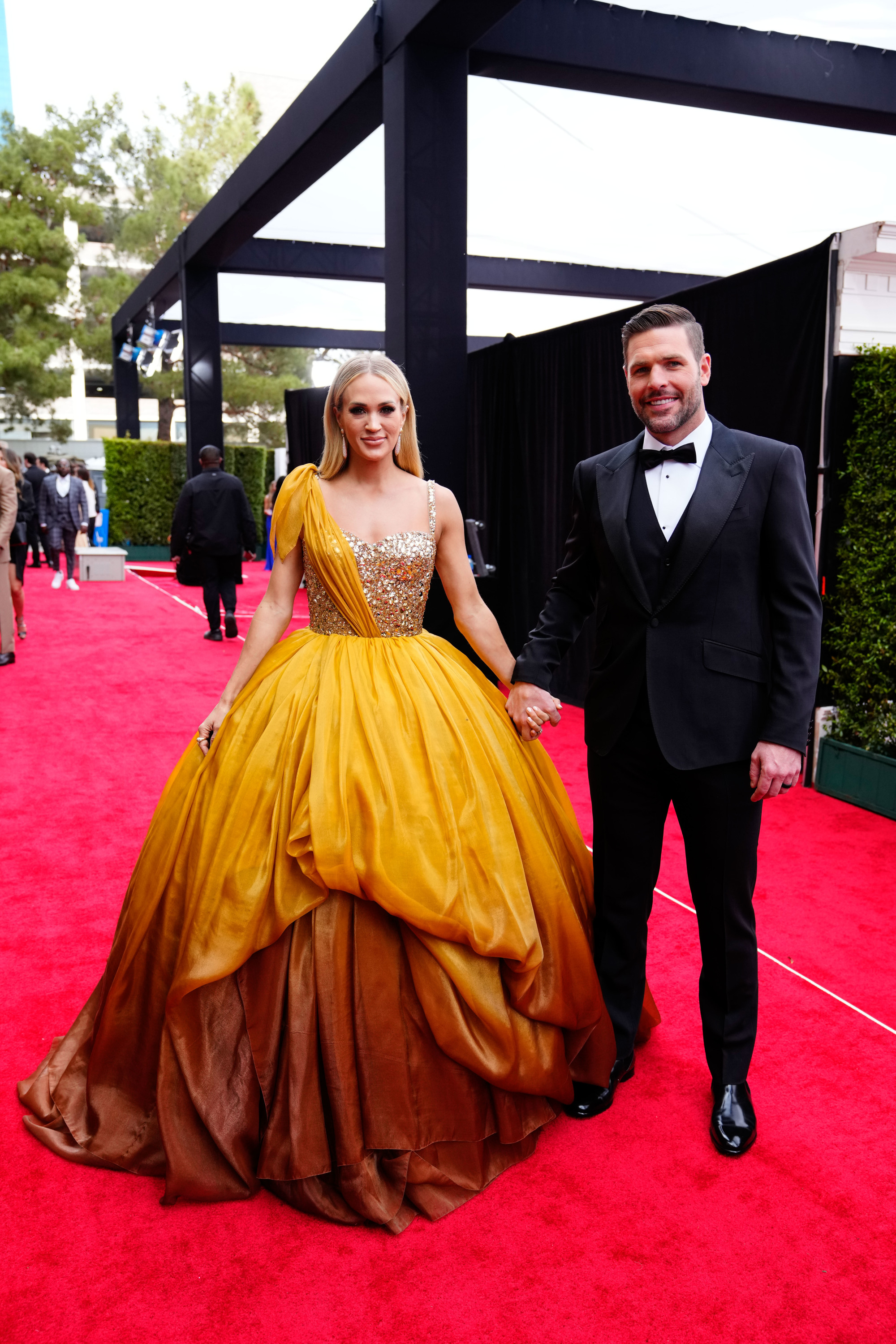 A cantora e compositora Carrie Underwood com vestido amarelo com corpete de paet&ecirc;s.