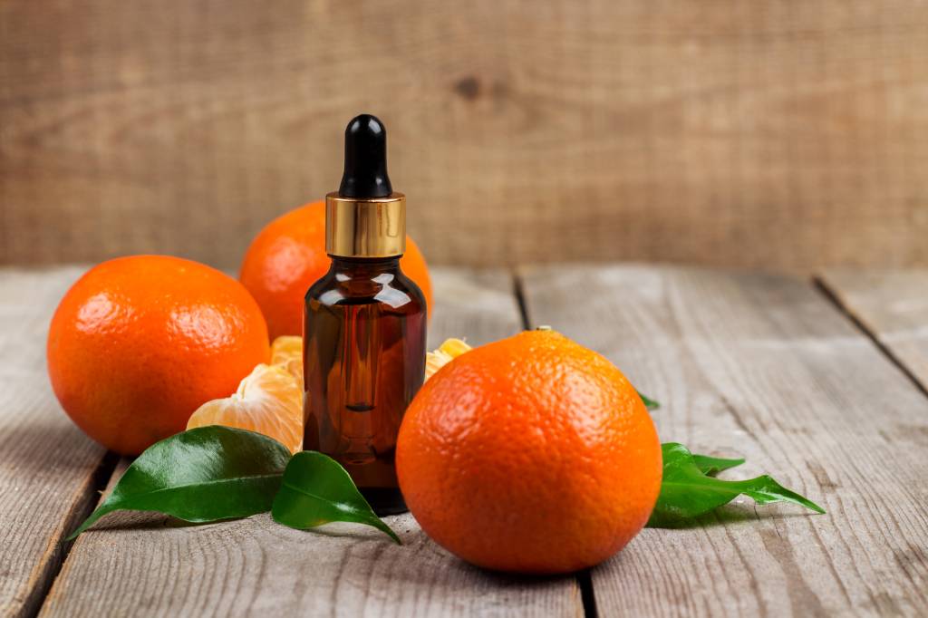 Organic tangerine essential oil Óleo de mandarina ao lado da fruta