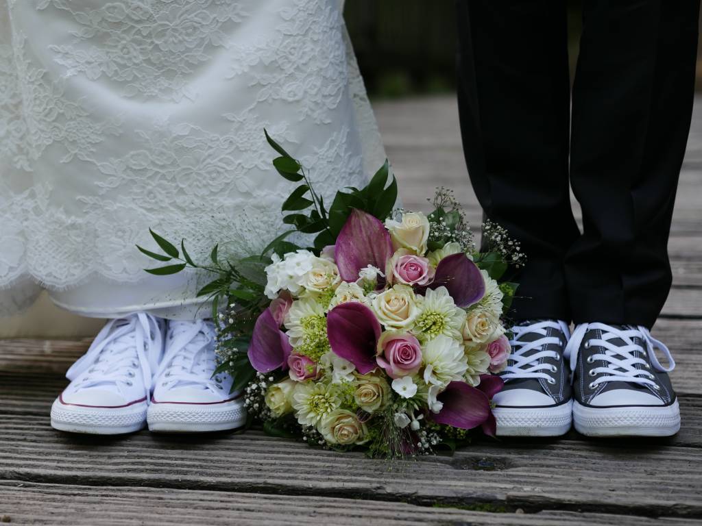 Partial shot of bridal couple with funny wedding shoes Noiva e noivo de all star