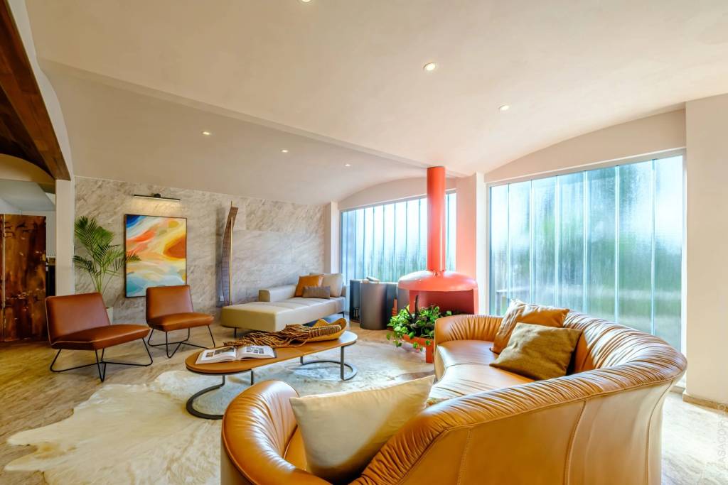 Teto circular e lareira em tom coral são destaque deste projeto de living