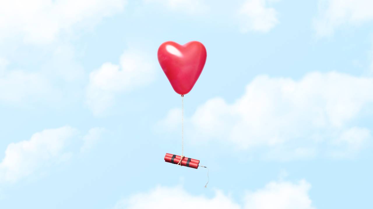 Conceptual photograph of a heart shaped red balloon tied to a dynamite bundle floating in the clouds, could illustrate concepts related to bad love relationships and similar. Could also illustrate the opposite of being newly in love were everything is exciting and a little dangerous in a good way or even just the thrill