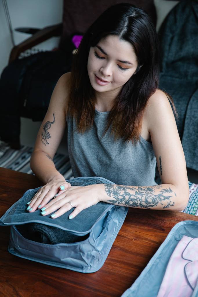 Mulher organizando roupas em organizadores de armário