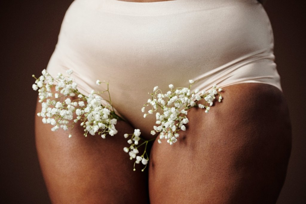 Mulher com flores brancas na calcinha