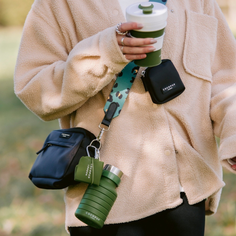 Mulher carregando uma bolsa tiracolo com itens essenciais anexados em sua alça