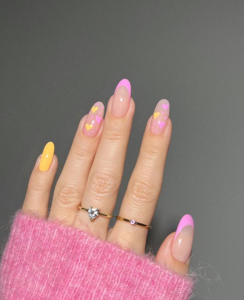 nail art amarela com desenhos de coração