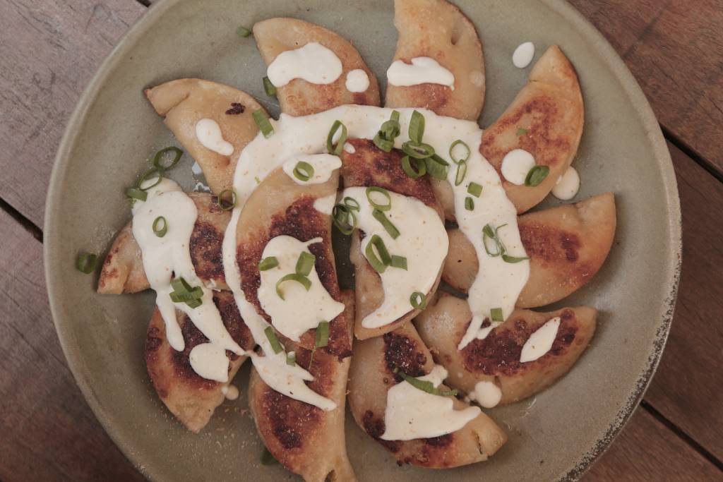 Pierogi de Abóbora e Puxuri é servido com creme azedo e cebolinha verde