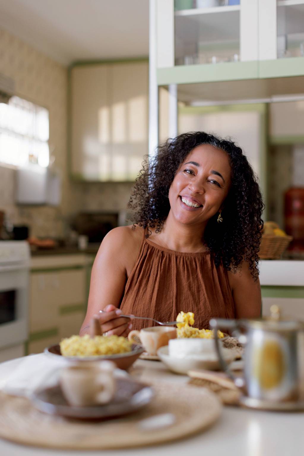Patty Durães sintomas menopausa Mulher negra sorrindo na mesa de café da manhã