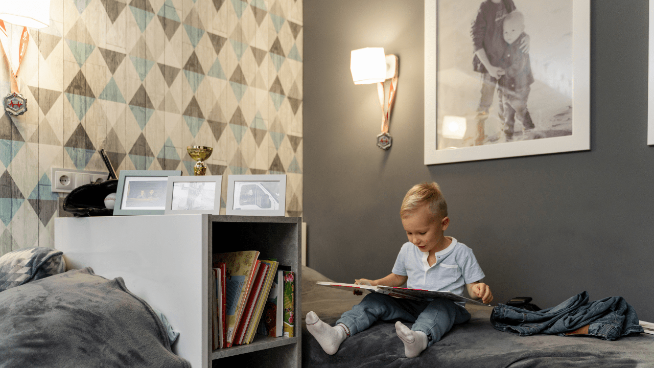 Imagem de criança lendo em quarto infantil sentada na cama