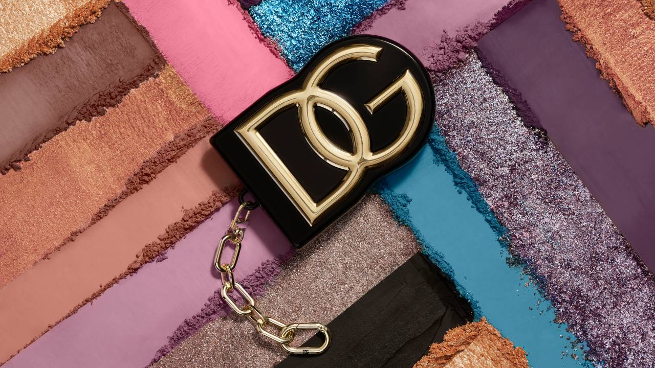 Imagem com diversas cores ao fundo e ao centro as letras DG