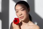 Mulher coreana segurando uma rosa vermelha