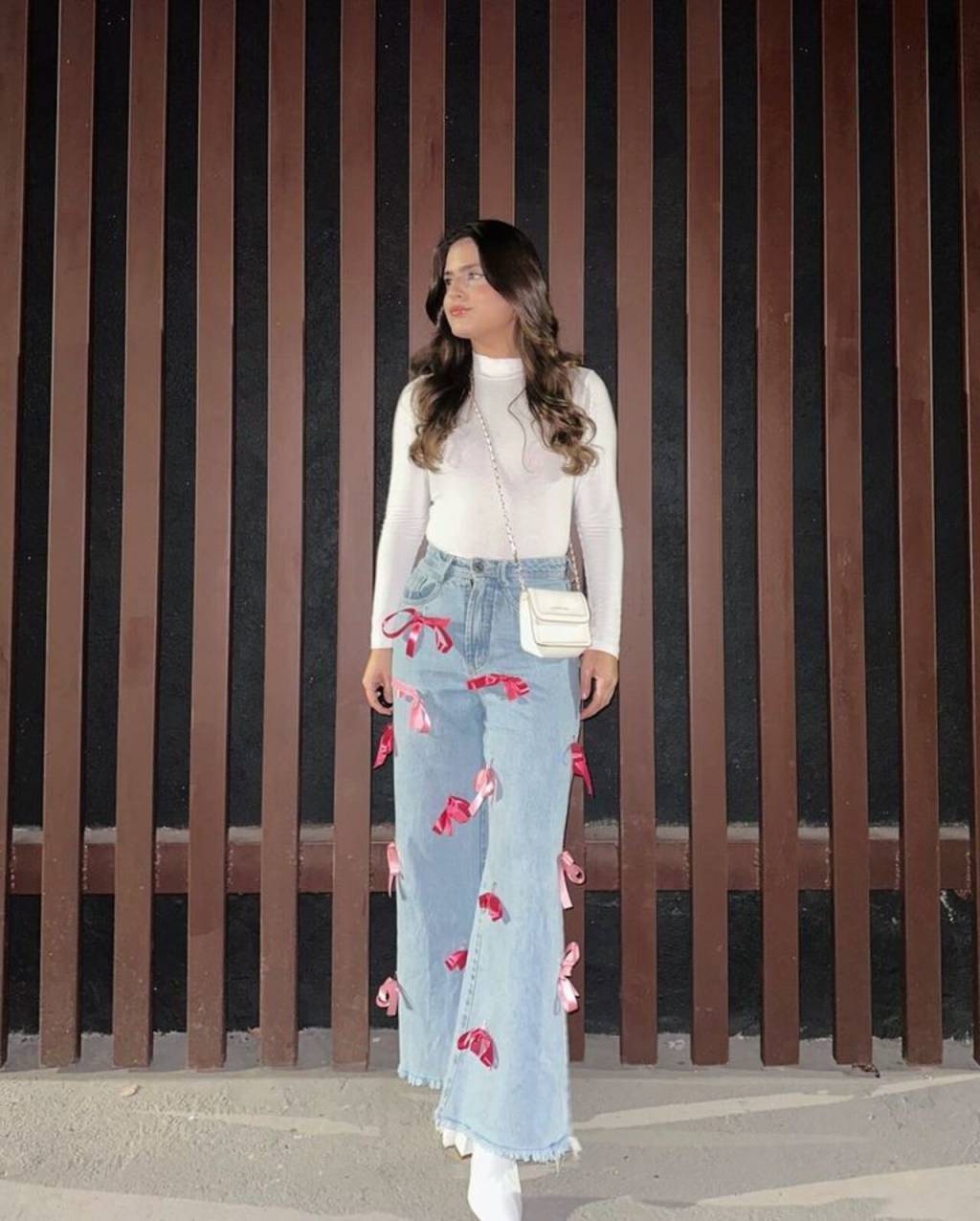 customização-junina (4) Imagem de mulher morena com calça personalizada com fitas em forma de laços na cor rosa.