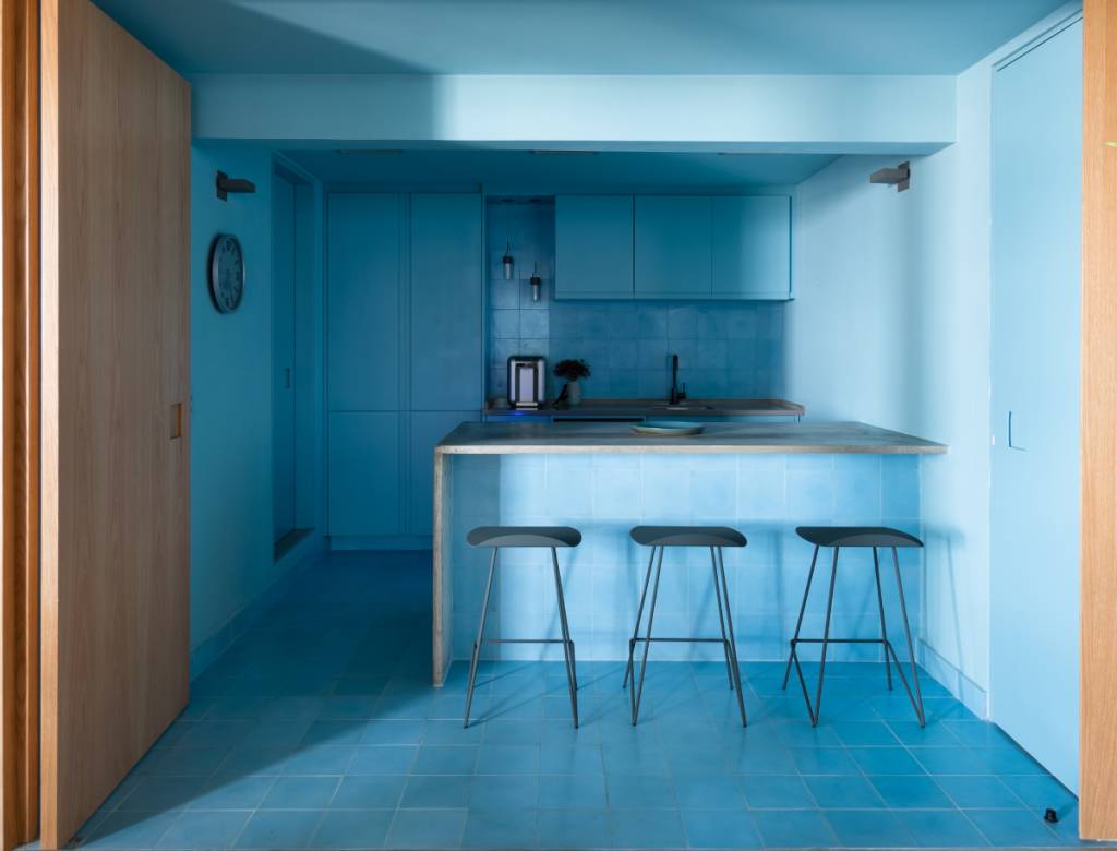 Ladrilho hidráulico no piso e backsplash segue a mesma cor dos armários e da pintura da cozinha | Projeto assinado pelo escritório Rawi Arquitetura + Design