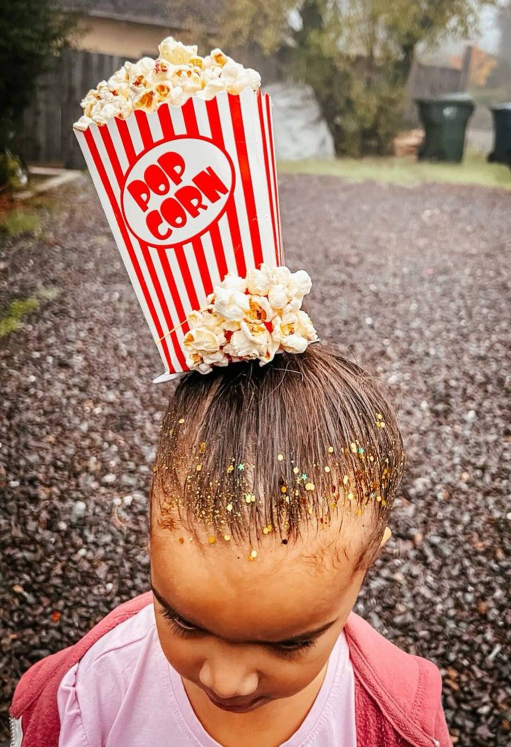 penteado-maluco-junino (12) Imagem de cabelo infantil feminino com caixa de pipoca e pipocas ao redor.