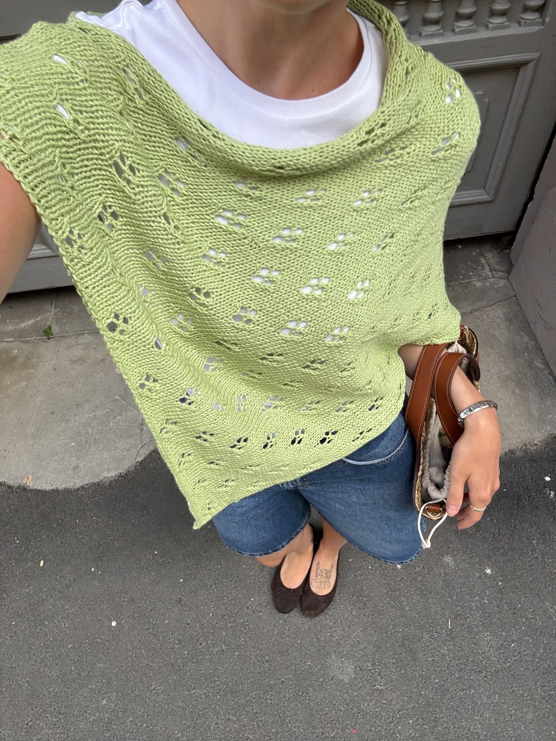 Look com poncho de croch&ecirc; verde e short jeans