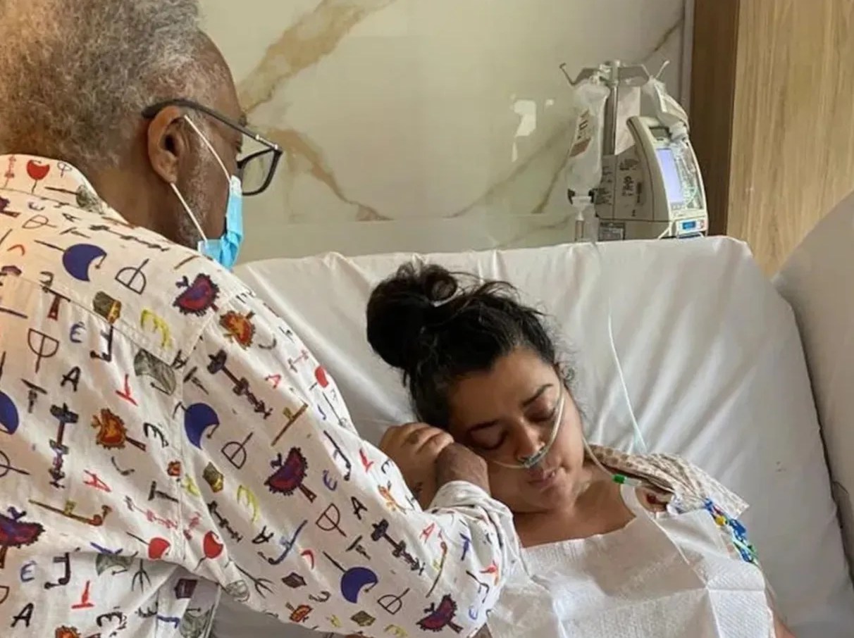 Gilberto Gil ao lado de Preta Gil durante tratamento contra câncer no hospital.