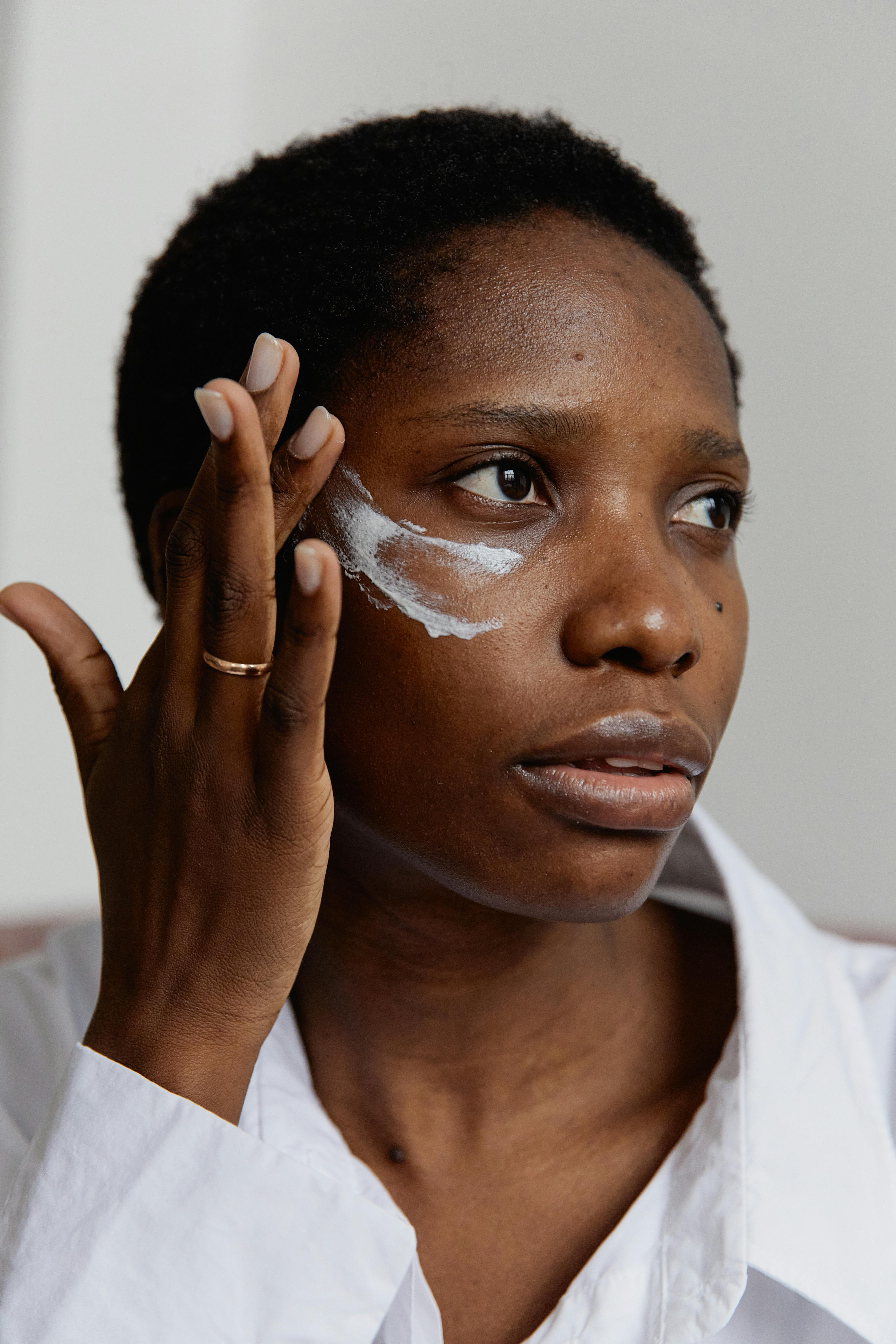 Imagem de mulher negra usando creme com efeito de microagulhamento.