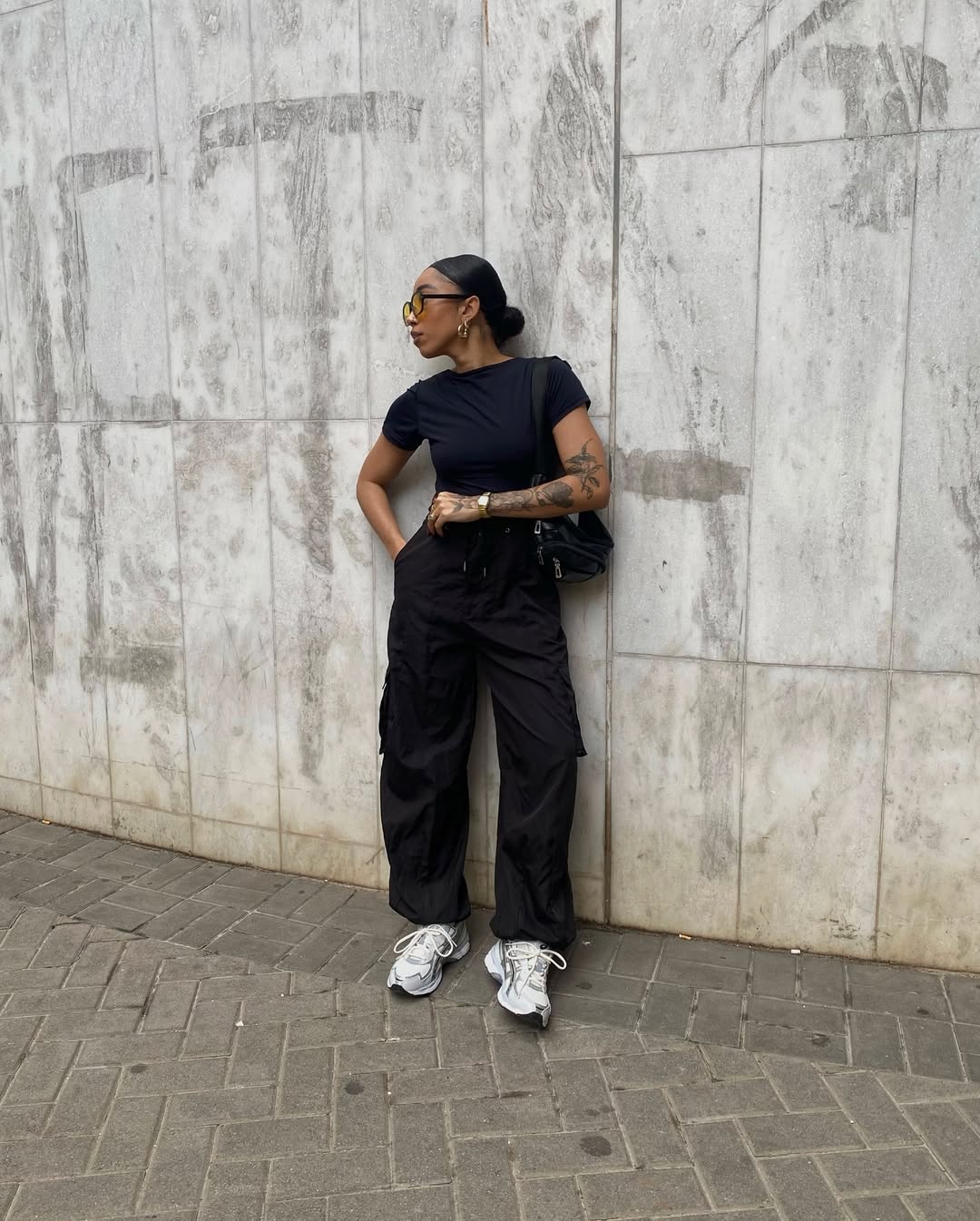 Look com t&ecirc;nis Asics branco e cal&ccedil;a jeans preta estilo cargo