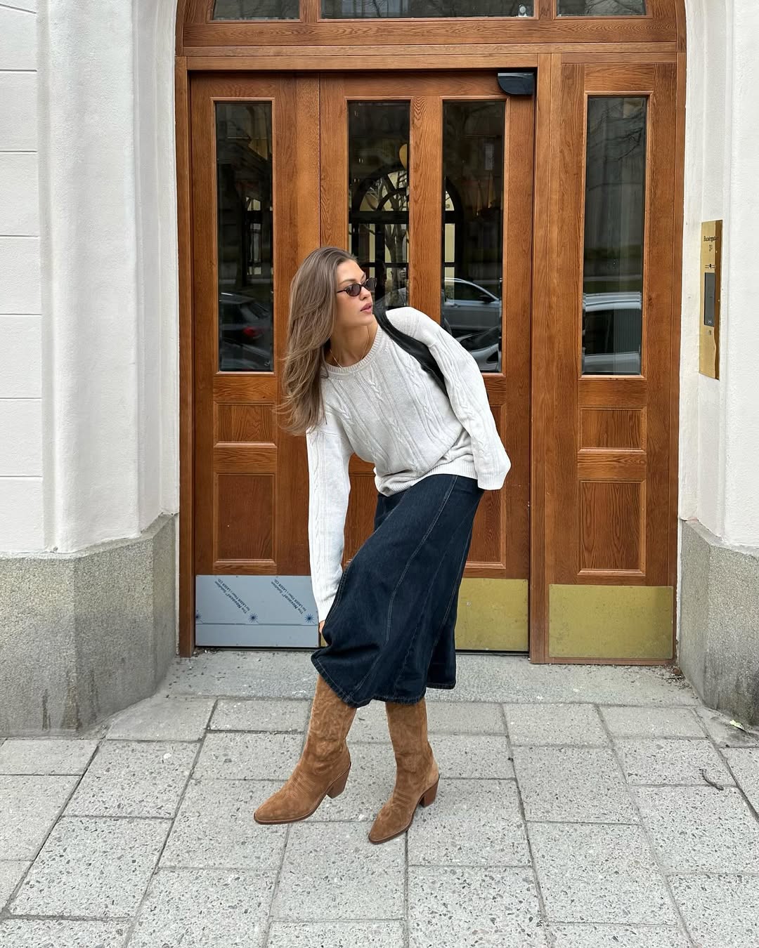Look com saia jeans, su&eacute;ter off-white e bota caramelo no estilo boho