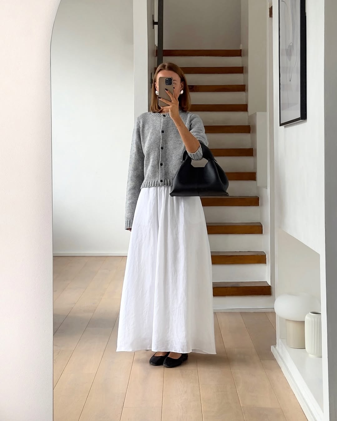 Look minimalista com cardigan cinza e saia longa branca