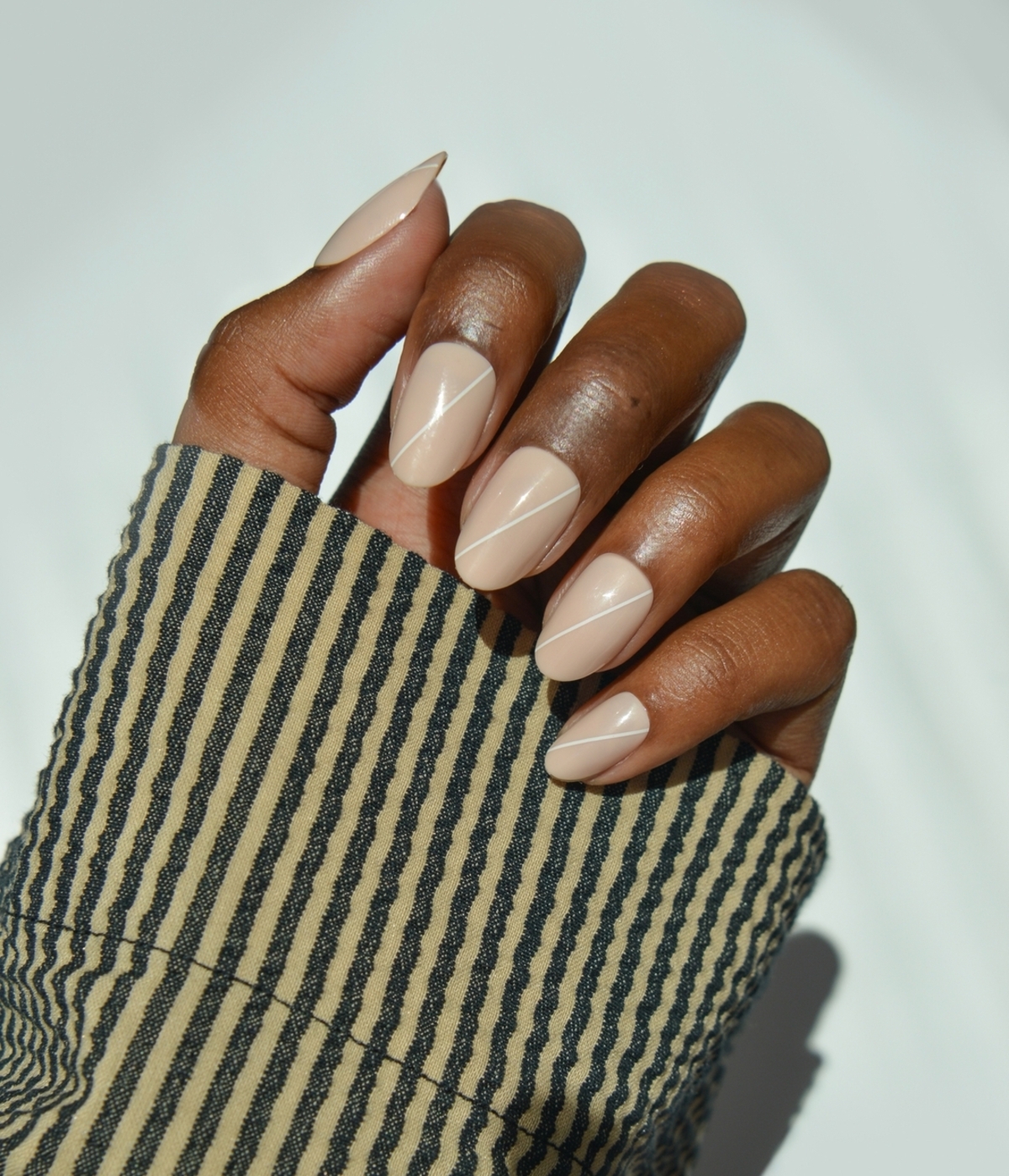 Imagem de unhas amendoadas curtas e nude.