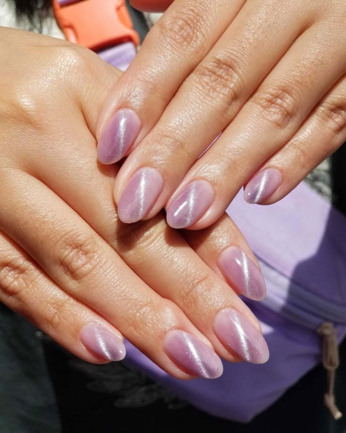 Imagem de unhas amendoadas lil&aacute;s e curtas.