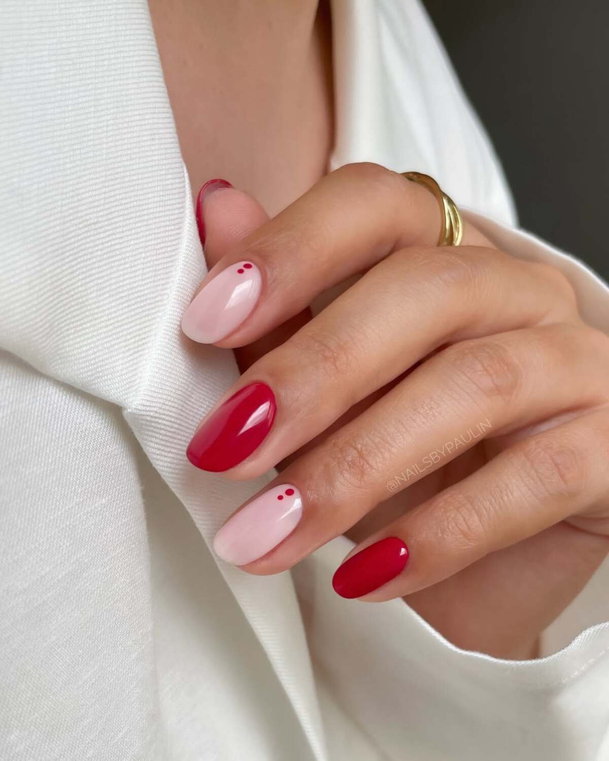 Imagem de unhas vermelhas amendoadas curtas decoradas.