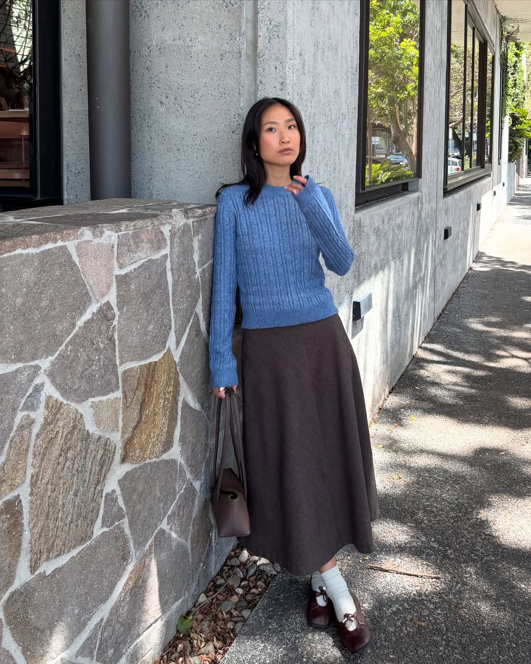 Look com su&eacute;ter azul e saia marrom para um visual cl&aacute;ssico e delicado