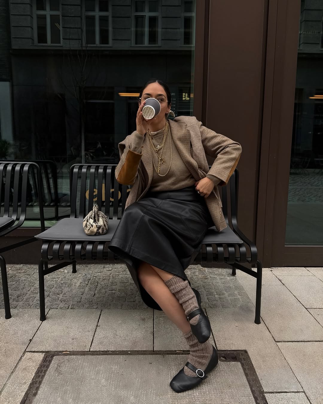 Look elegante com saia de couro e sapatilha preta com meia marrom