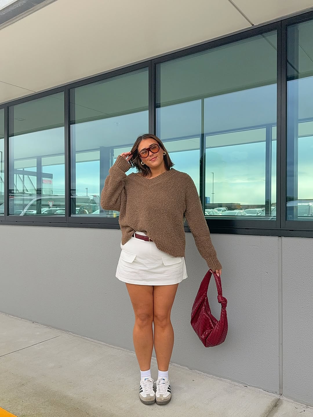 Look casual com su&eacute;ter marrom e minissaia branca
