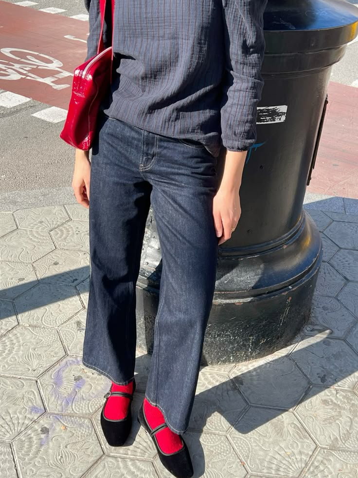 Look casual com jeans e sapatilha preta com meia vermelha