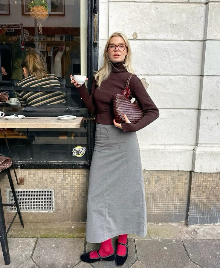 Look com saia longa cinza, gola alta e sapatilha com meia vermelha